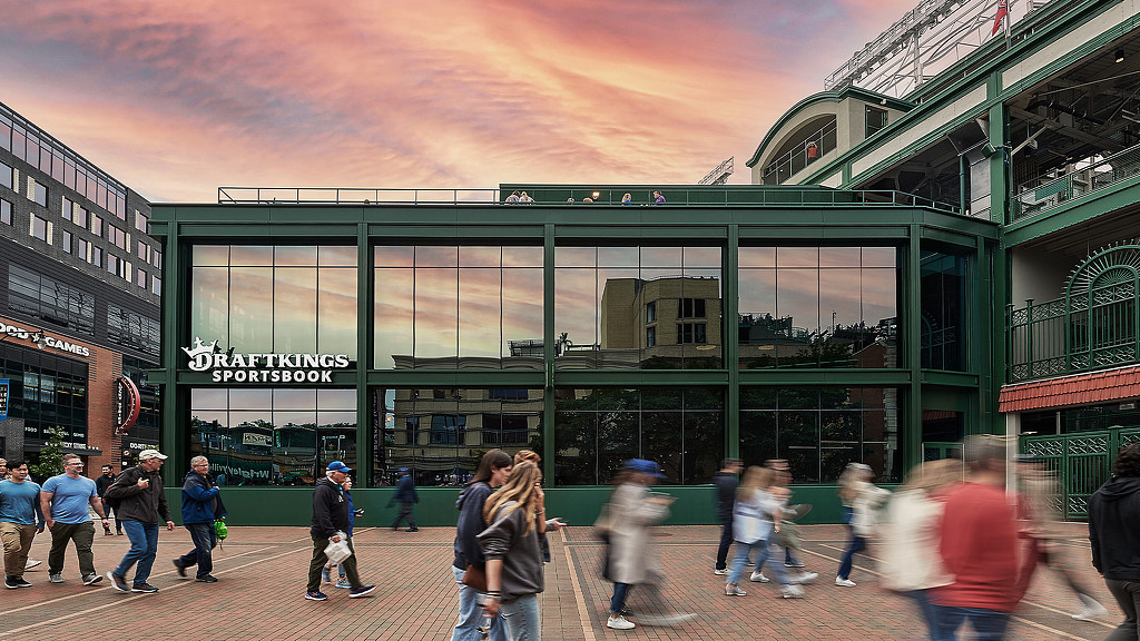 A group of people outside a building with large reflective windows and green structure