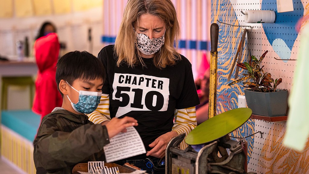 Chapter 510 Swan's Market volunteer helping boy with writing activity