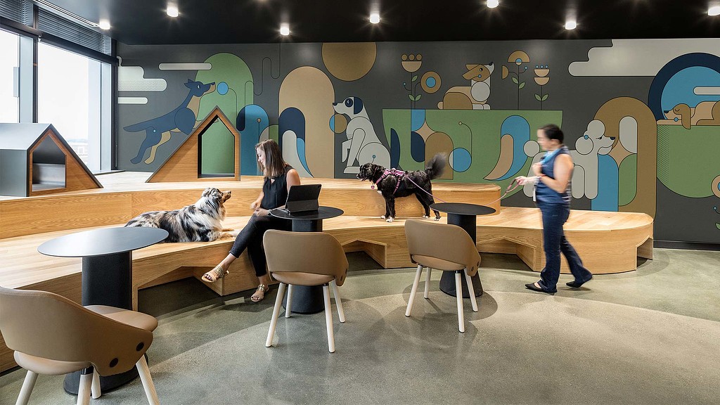 A group of people in a room with a large map on the wall.