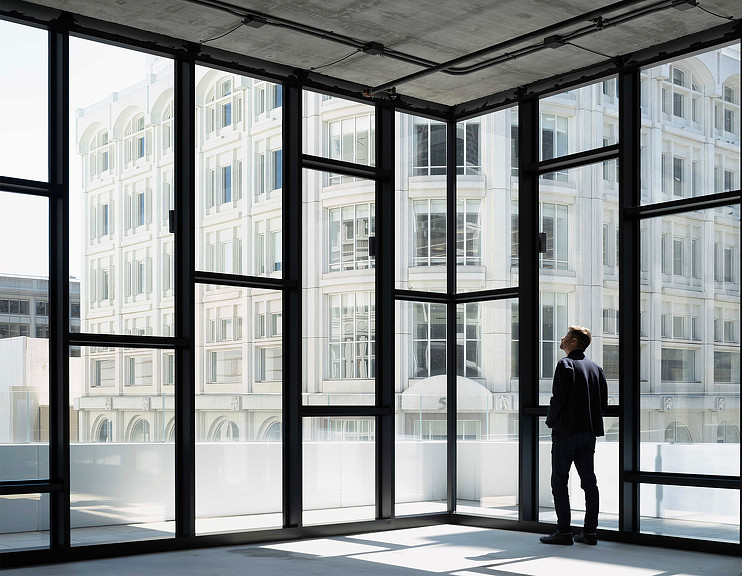 A man looking out the 100 Stockton windows