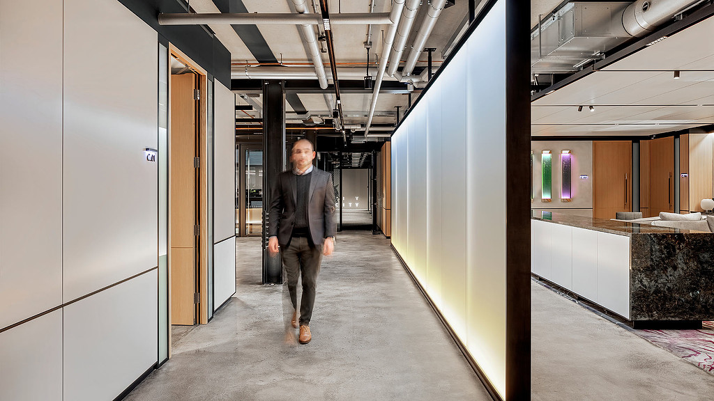 A man walking down the hallway of a financial services firm