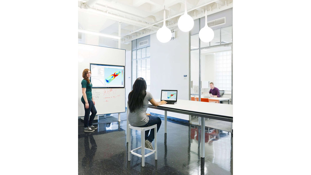 A person sitting at a table with a laptop.