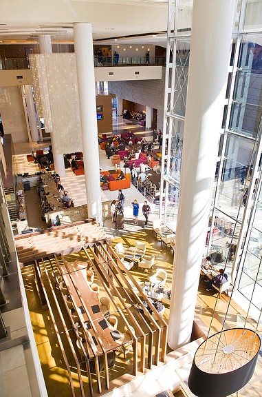 A large room with a large group of people and a large group of tables and chairs.
