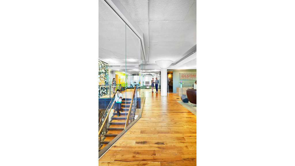 A group of people walking down a hall way.