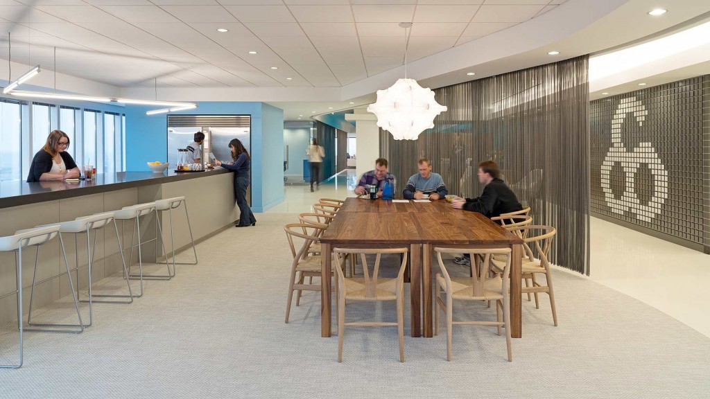 A group of people sitting at a table in a room with white walls.