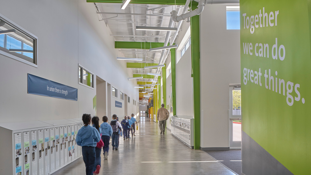 A group of people walking in a hallway.