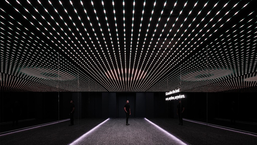 A man standing in the center of Verizon Innovation Center, San Francisco room with digital installation