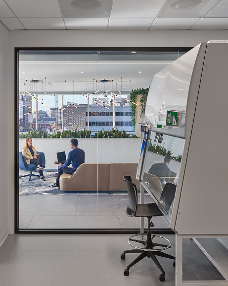 A man and woman working out in a room with a large window.