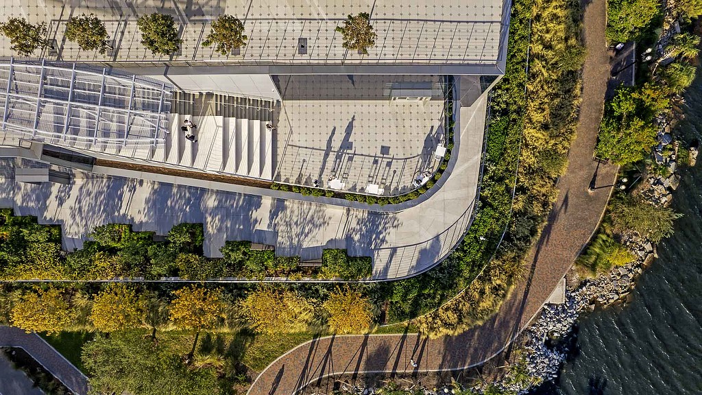 A large stadium with a road and trees around it.