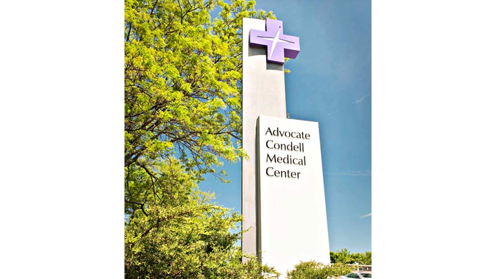 A tall white tower with a sign on it.