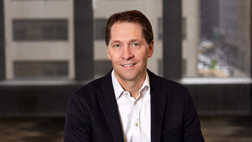 A man in a suit smiling.