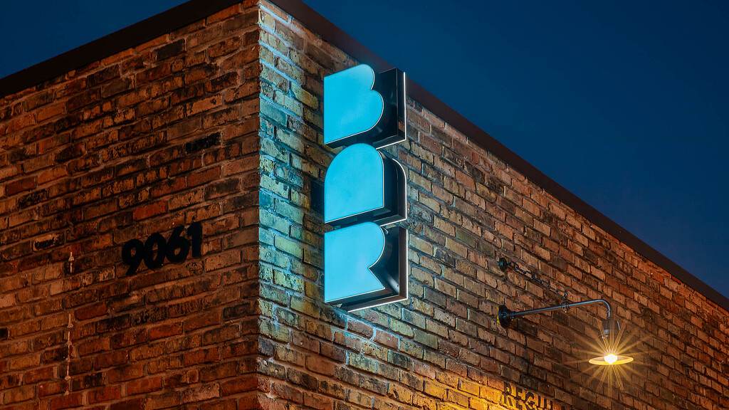 Illuminated blue BAR sign outside Bar Bludorn