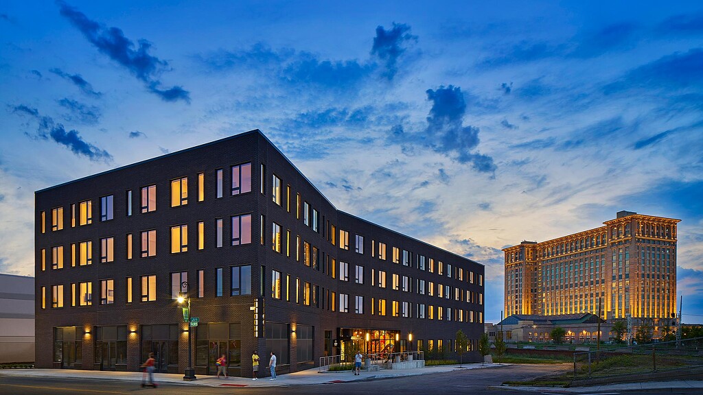 A building with windows and people walking around.