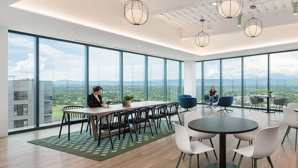 A room with tables and chairs and large windows with large windows.