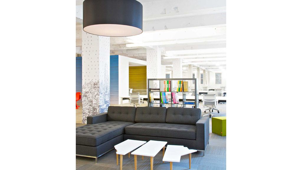A living room with a couch and a lamp.