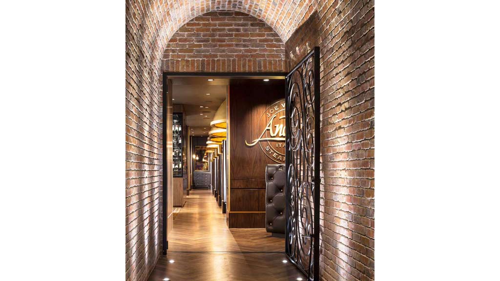 A hallway with a door and a brick wall.