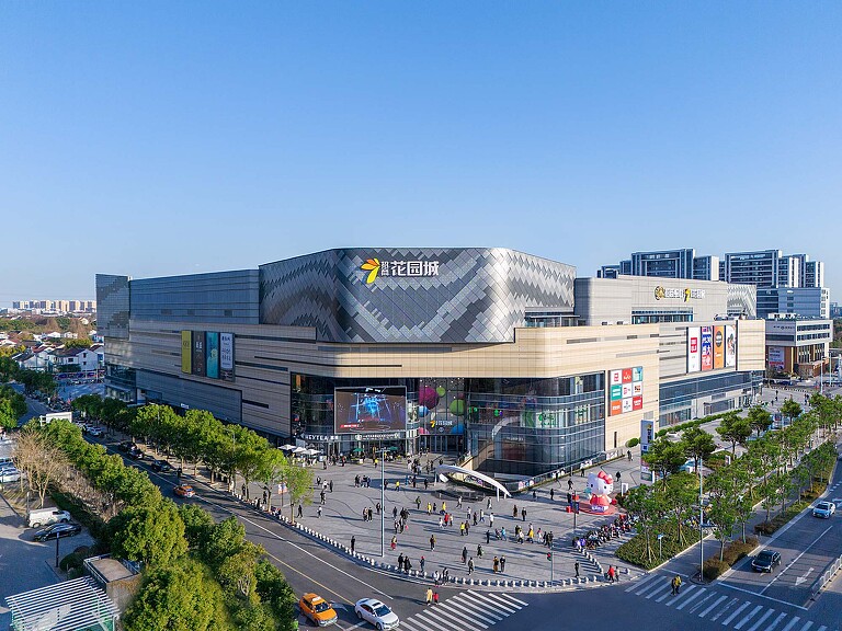 A large stadium with a crowd of people in front of it.
