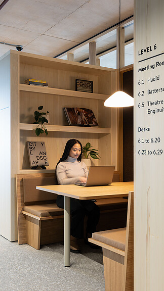 A woman working on her laptop in a quiet corner of Buro Happold London