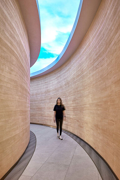 Woman walking through curved hallway at Kayanee