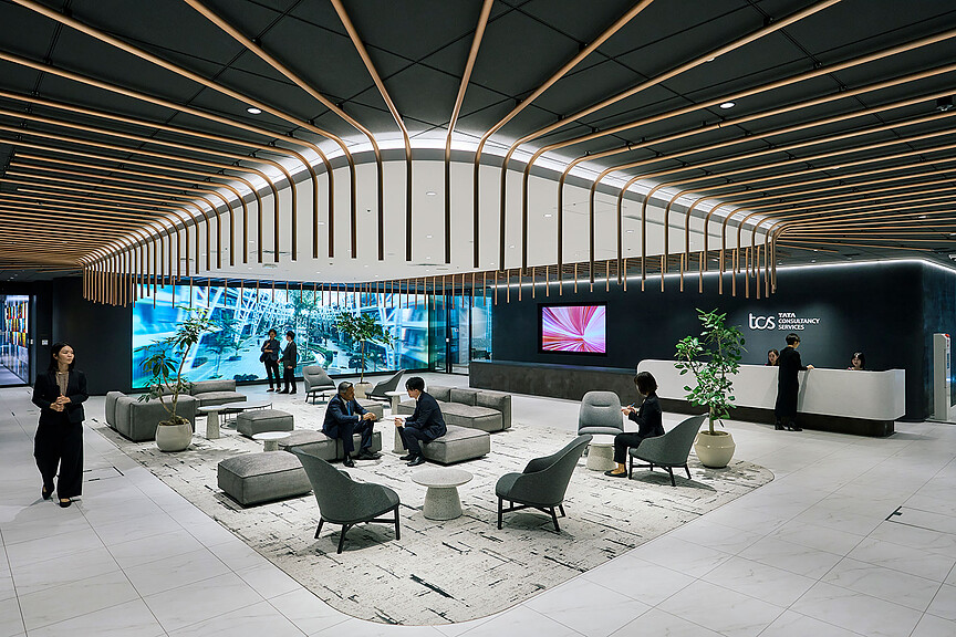 A group of people in a room with large screens.