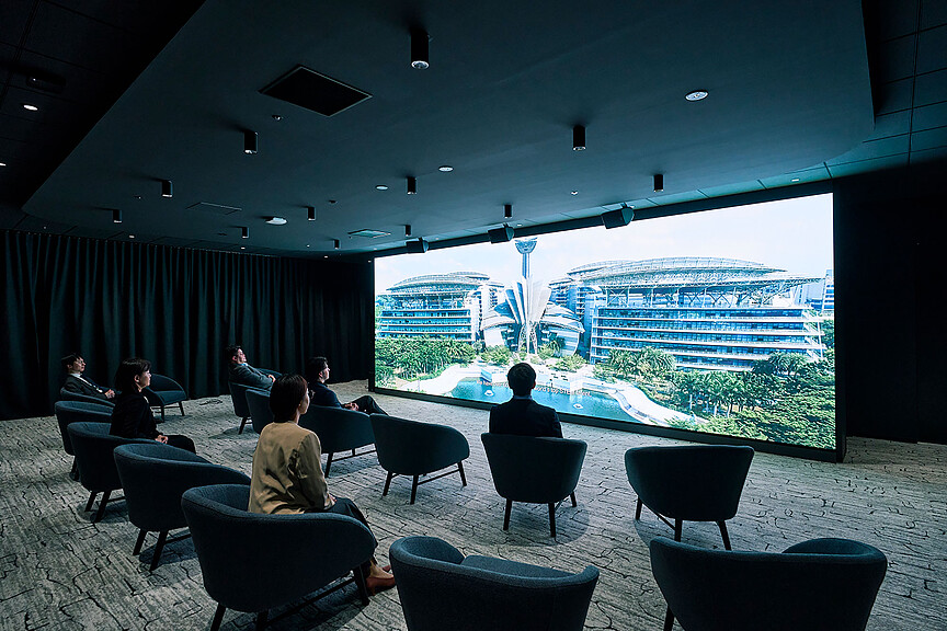 A group of people sitting in chairs in a room with a large window.