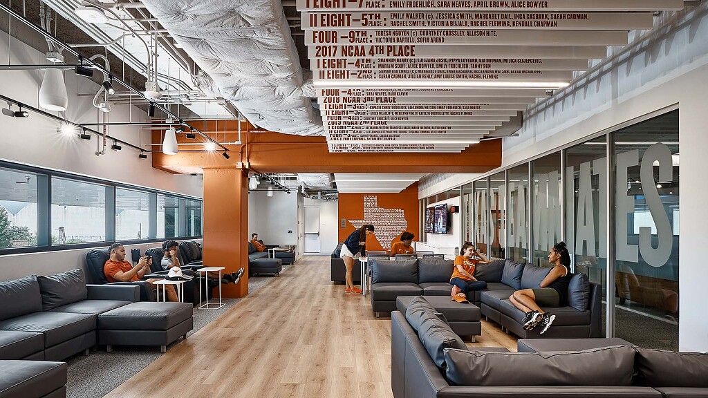 A group of student athletes sitting on couches in a lounge.