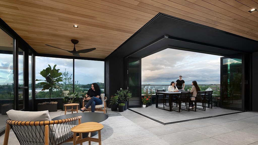 A group of people sitting at a table in a room with a large window.