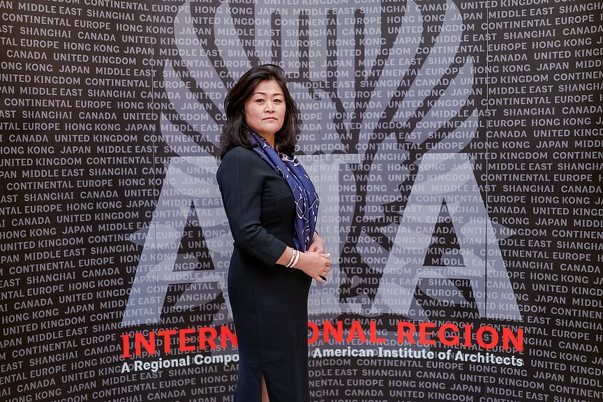 A person standing in front of a wall with text.