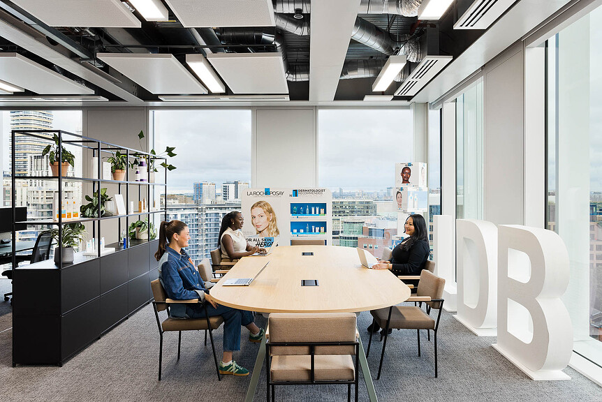 A group of people sitting around a table in a room with a large window.