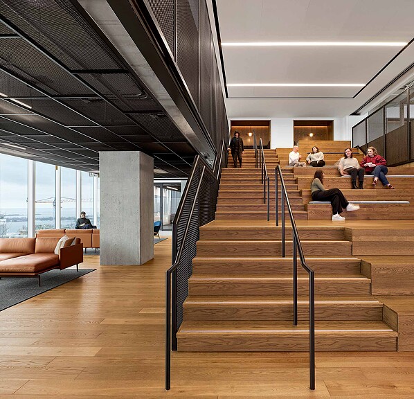 A group of people sitting on the stairs of a building.