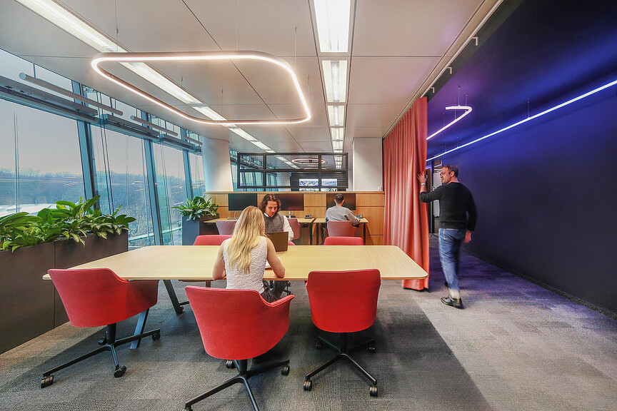 A group of people sitting at a table in a room with a large window.