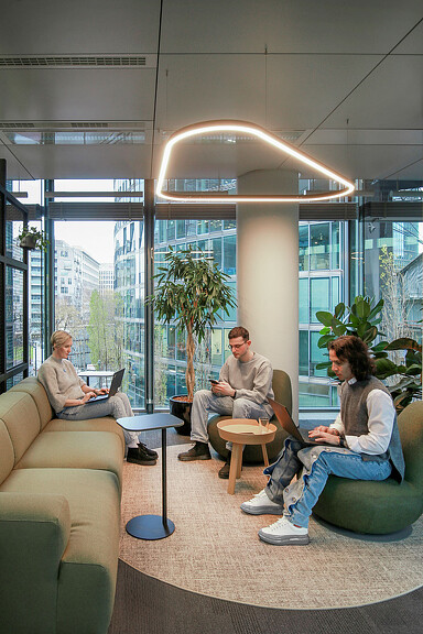 A group of people sitting in a room with a large window.