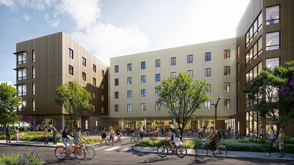 A group of people riding bikes in a courtyard with buildings in the background.