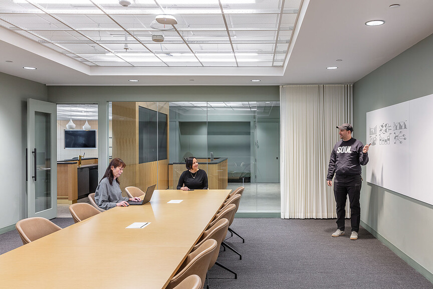 A person standing in front of a table with people sitting at it.