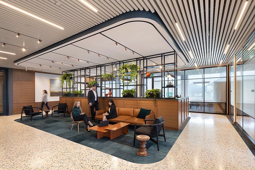 A group of people sitting in a room with a large glass ceiling.