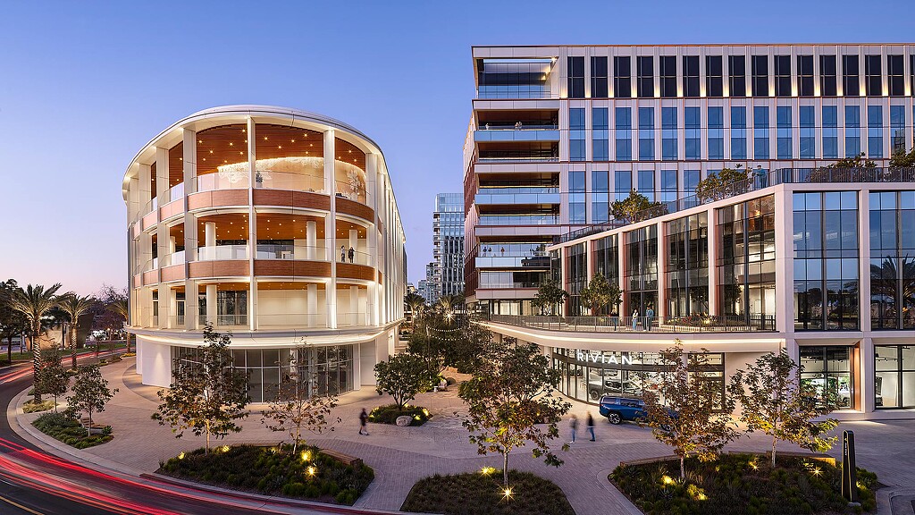 A building with a courtyard and trees in front of it.