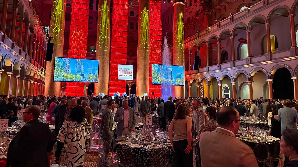 A large crowd of people in a building with colorful walls.