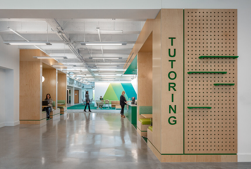 A group of people in a large room with green and white walls.