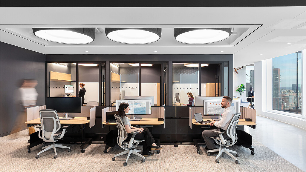 A group of people sitting at a table with computers.