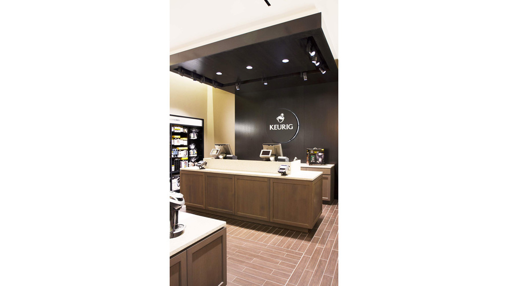 A kitchen with a counter top and a black wall.