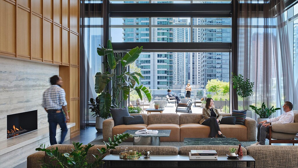 A group of people sitting in a living room with a fire.