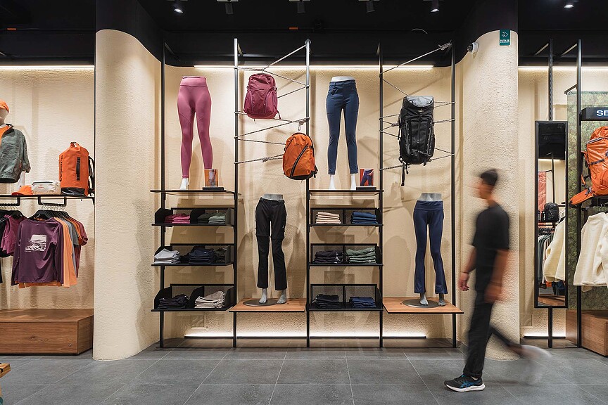 A person standing in front of a display of clothing.