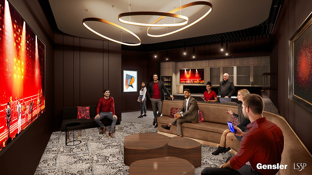 A group of people sitting in a suite with a large screen.