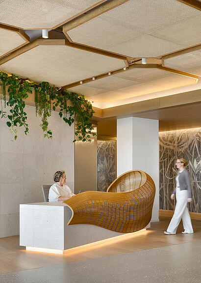 A woman standing next to a man sitting in a chair.