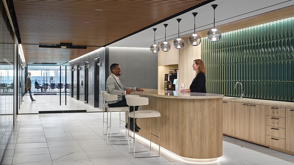 A man and woman sitting at a table in a large room.
