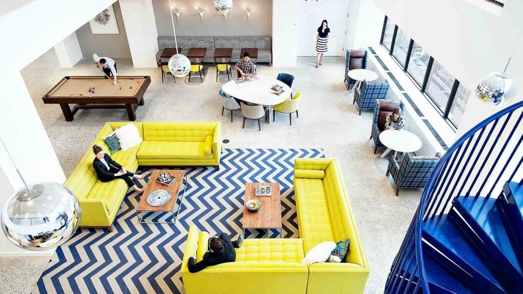 A room with yellow couches and tables.