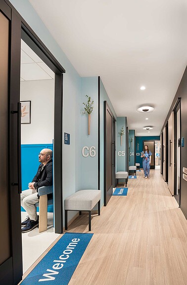 A person sitting on a bench in a hallway.