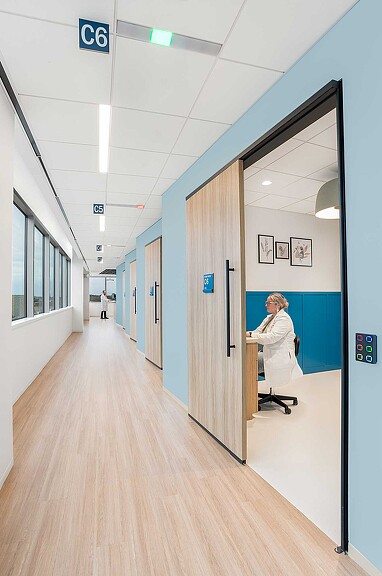 A person in a white coat in a hallway.