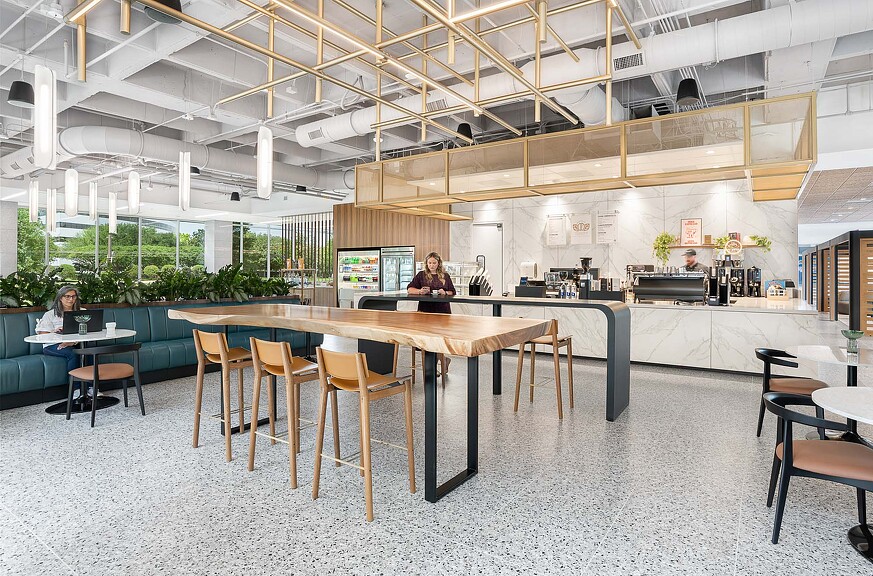 A couple of people sitting at a table in a large room with a large glass ceiling.