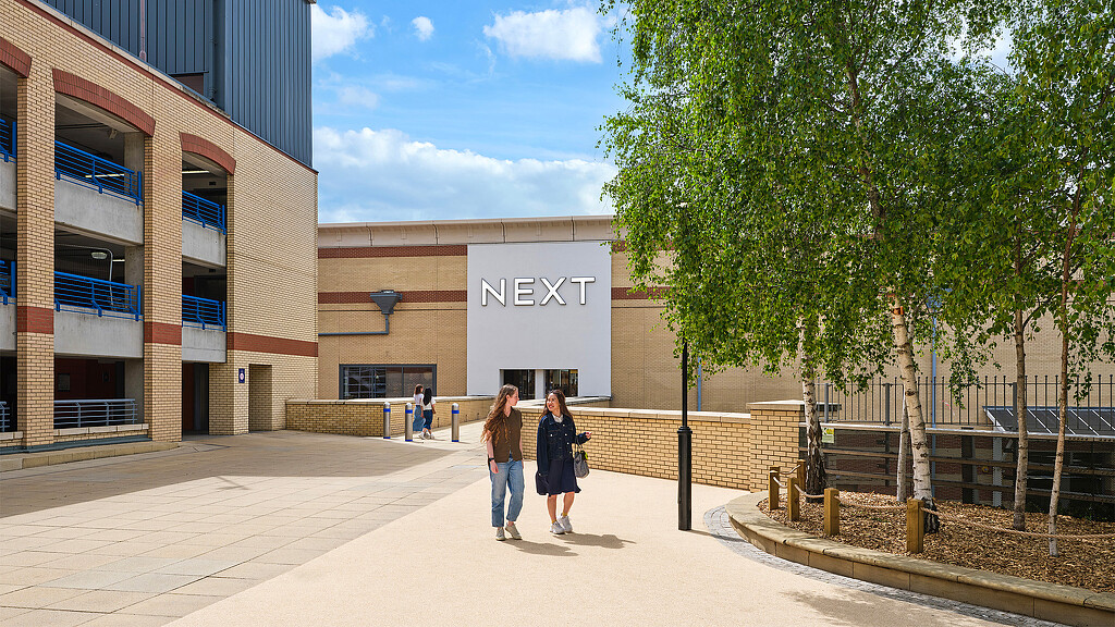 A couple of women walking outside of a building.